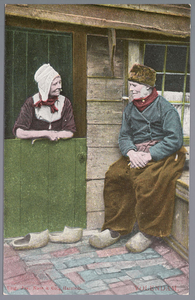 WAT001013322 Een man en vrouw aan het kletsen in klederdracht.