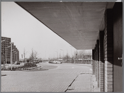 WAT001008103 Parkeerplaats bij station NS Wheermolen. Op de achtergrond een rij flats aan de Meteorenweg.