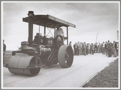 WAT001017175 Foto: Milieugedeputeerde G. de Boer walst met een Engelse 'Marshall' stoomwals de werkweg naar de ...
