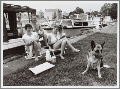 WAT001017321 Heerlijk met z'n allen genieten van de zon.Het hele gezin met hond langs de waterkant.