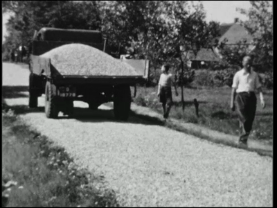 1068BB08146 Een bedrijfsfilm rond het verharden van een zandweg, met beelden van:- Het egaliseren van het pad;- Het ...