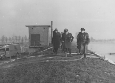 17160 Hoog water in 1955 achter de meelfabriek van Noury & van der Lande bij de Koerhuisbeek. V.l.n.r.: Mr. H.W. ...