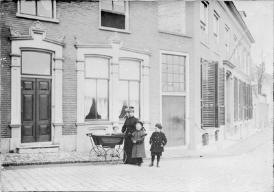 281 Reproductie van een foto. Moeder met drie kinderen voor een woonhuis., 10-04-1945 - 30-04-1945
