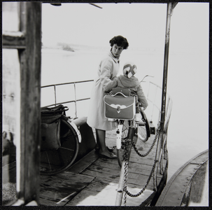 6 Een wielrijdster wacht op de aanlegsteiger op het pontje De Stokvis om overgevaren te worden naar de Worp., ...