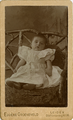 12-0025 Baby met op de achtergrond een hekje, ca. 1888