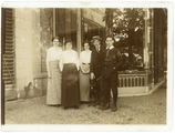 13-0015 Drie jonge vrouwen en twee jonge mannen staan met een hond naast een gebouw, 1900-1940