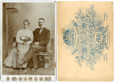 13-0016 Een jonge vrouw met een waaier in de hand en een jongeman met snor poseren zittend op een bankje, 1890-1905