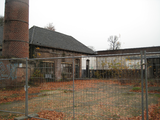 10 vervallen textielfabriek achter hek aan de Hofstraat met schoorsteen op de achtergrond, 18-11-2008
