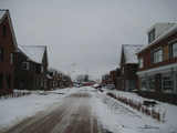 10476 bevroren straat in nieuwbouw wijk met op de achtergrond de besneeuwde molen de Zwaan, 11-01-2010