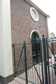 1592 IJzeren hek bij hoofdingang aan zijkant. Deur met Oculus in muur er boven, synagoge Borculo, 21-07-2010