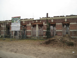 34 vervallen textielfabriek aan de Hofstraat met bord van de projectontwikkelaar waarop de restauratie wordt ...