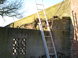 4689 afgebrokkeld stuk muur waar een ladder tegenaan is geplaatst, 11-02-2009