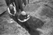 23 Het opgraven van de stoffelijke resten van de Britse Corporal Bernard S. Atkinson, van het 1st (Airborne) Battalion, ...