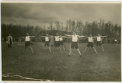 21 Sporters doen gymnastiekoefeningen in groepsverband, 1928-1935