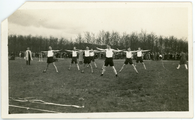 30 Sporters doen gymnastiekoefeningen in veld, 1928-1935