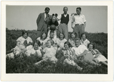 35 Jongeren liggen en staan in het veld met handbal, 1928-1935