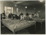 1 Architect H. van Kamp (vierde van links, liggend op tafel) aan het werk, 1946-1955