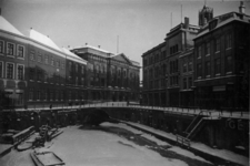 66907 Gezicht op de Stadhuisbrug bedekt met sneeuw te Utrecht, vanaf de Bezembrug. Op de voorgrond de bevroren ...