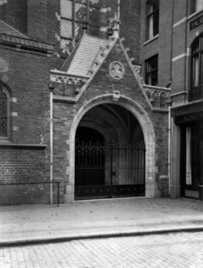 81822 Gezicht op het aan de Steenweg gelegen herbouwde noordportaal van de Buurkerk (Buurkerkhof) te Utrecht, uit het ...