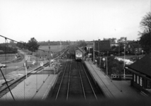 153293 Gezicht vanaf de voetgangersbrug op de sporen en de perrons van het N.S.-station Putten te Putten. In het midden ...