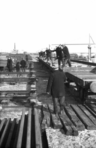 164327 Afbeelding van het beladen van enkele wagens met spoorstaven op de stapelplaats van de N.S. te Crailoo.