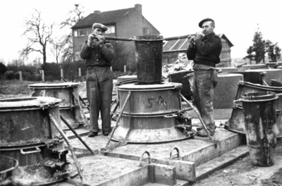 164315 Afbeelding van de fabricage van betonnen funderingsblokken voor bovenleidingsmasten op het emplacement van het ...