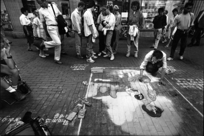 70751 Afbeelding van een straattekenaar en toeschouwers voor de ingang van de Boekhandel Broese-Kemink b.v. ...