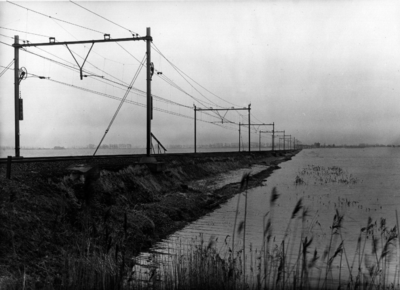 157046 Afbeelding van de gedeeltelijk door water weggespoelde spoordijk nabij Lage Zwaluwe, na de watersnoodramp.