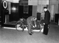 163887 Afbeelding van het voor verzending gereedmaken van een fiets bij de bagagebalie van het N.S.-station Roosendaal ...