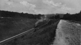 161149 Gezicht op de ingraving van de spoorlijn Ede-Arnhem bij Oosterbeek, met een trein getrokken door een ...