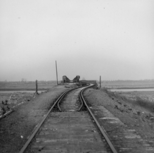 158912 Gezicht op de spoorbaan en de tijdelijke spoorbrug over de Maas bij Gennep, uit het westen.