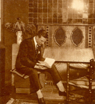 80449 Afbeelding van een lezende man bij een gashaard, als reclame voor gasverwarming.