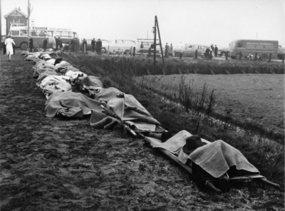 157504 Afbeelding van onder dekens toegedekte slachtoffers van de treinramp te Harmelen langs de spoordijk.