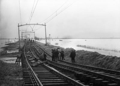 157035 Afbeelding van de gedeeltelijk weggespoelde spoorlijn nabij Moerdijk, na de watersnoodramp.