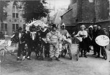 64802 Afbeelding van een groep verklede wielrijders (waaronder waarschijnlijk Arie Nebbeling) op het Nicolaaskerkhof te ...