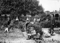 121115 Afbeelding van enkele tuinierende kinderen in de schooltuin van de Openbare School voor Buitengewoon Lager ...