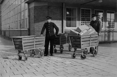 160632 Afbeelding van twee beambten van de P.T.T. met postkarren bij het Stationspostkantoor (Laan van Puntenburg 5) te ...