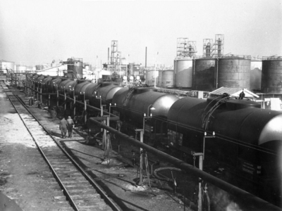 164321 Afbeelding van ketelwagens met ruwe aardolie bij het overlaadstation van een olieraffinaderij te Pernis.