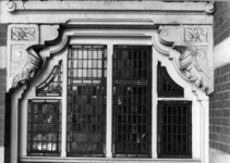 155122 Afbeelding van twee gebeeldhouwde consoles boven een deur met een glas-in-lood bovenlicht van het N.S.-station ...