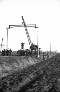 164320 Afbeelding van het plaatsen van een betonnen bovenleidingsportaal type GP langs de spoorlijn tussen Breda en ...