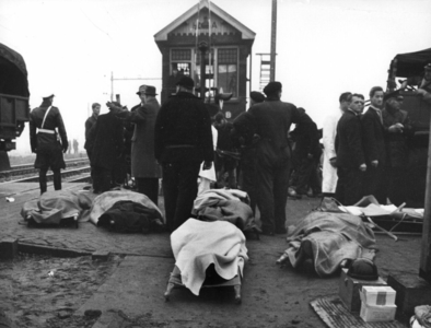 157532 Afbeelding van onder dekens toegedekte slachtoffers van de treinramp te Harmelen op de overweg in de ...