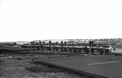 164326 Afbeelding van het beladen van enkele wagens met spoorstaven op de stapelplaats van de N.S. te Crailoo.
