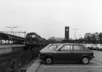 154556 Gezicht op de P+R-parkeerplaats bij het N.S.-station Nijmegen te Nijmegen met links langs het perron de trein ...