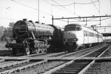 155468 Afbeelding van een electrisch treinstel plan V (mat. 1964) van de N.S. in nieuwe huisstijl-kleuren naast de ...