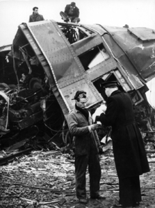 157506 Afbeelding van een heilsoldaat met koffie voor een reddingswerker met op de achtergrond het bij de treinramp te ...