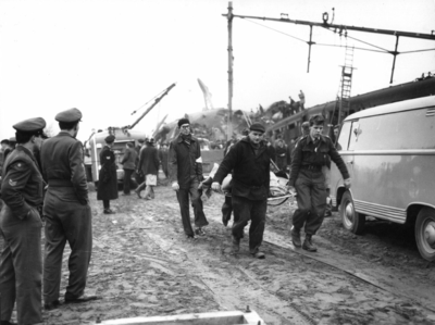 157529 Afbeelding van het afvoeren van een slachtoffer van de treinramp te Harmelen.