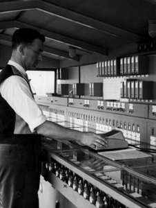 156464 Afbeelding van een seinhuiswachter bij het 120-voudig stelknoptoestel in het seinhuis A van het N.S.-station ...