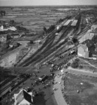 156383 Overzicht van de omgeving van de Woenselse Overweg te Eindhoven, met op de achtergrond het N.S.-station Eindhoven.