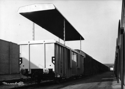 154129 Afbeelding van een perswagen van de N.S. voor het vervoer van schuimrubber te Kesteren met geopend dak.