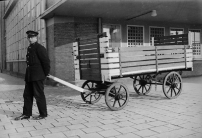 160633 Afbeelding van een beambte van de P.T.T. met een postkar bij het Stationspostkantoor (Laan van Puntenburg 5) te ...